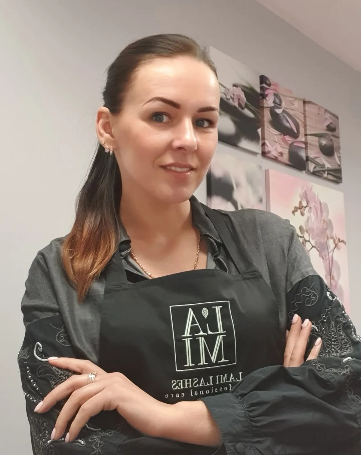 Speciāliste studijā, fonā attēli ar orhidejām